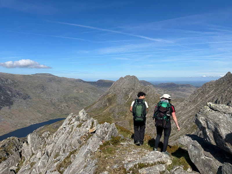 2 hill walkers on a high mountain ridge on a sunny day in the Lake District